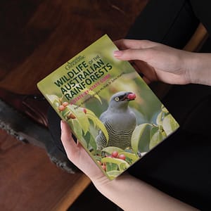 Hands holding a copy of the Wildlife of the Australian Rainforests book
